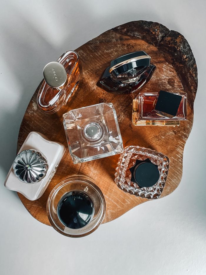 Stylish arrangement of luxury perfume bottles on a wooden tray, perfect for beauty theme.
