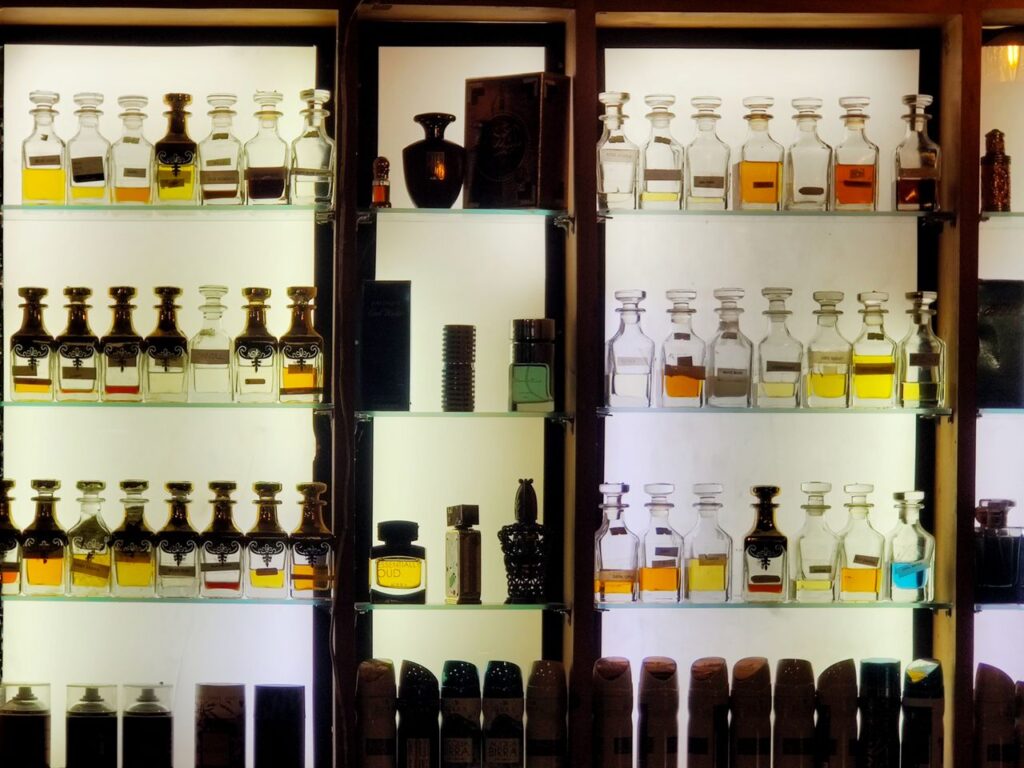 Aesthetic arrangement of diverse perfume bottles on illuminated shelves showcasing luxury fragrances.